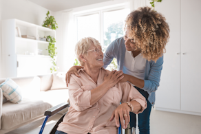 Life Assure Senior Woman Sitting In Chair And Laughing With Caregiver Nurse Blog